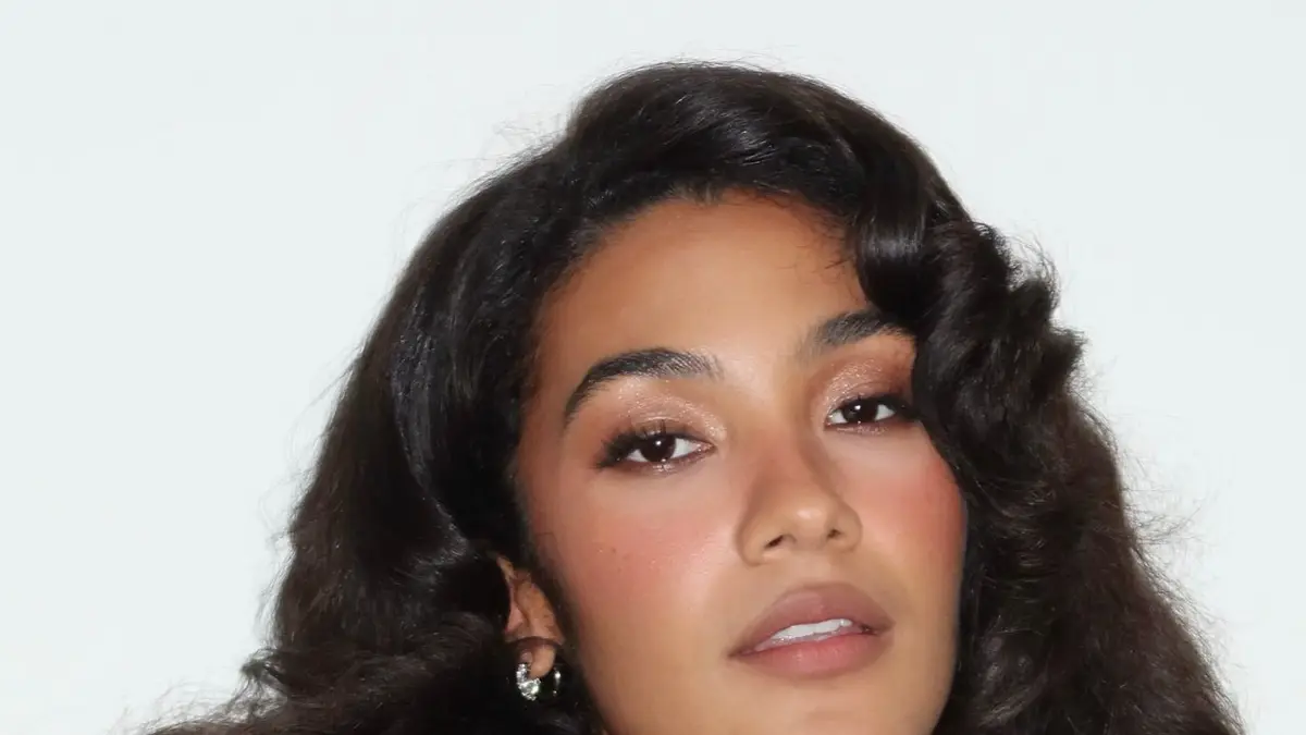 Modelo com maquiagem de alta definição e cabelo estilizado durante desfile de moda